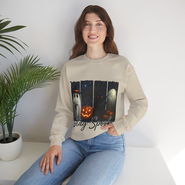 Woman wearing a beige sweatshirt with Halloween design sitting on a white surface.