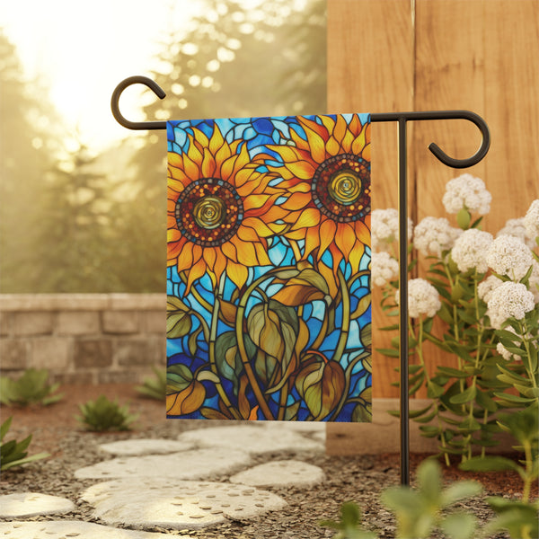 Decorative garden flag with sunflower design on a stand outdoors.