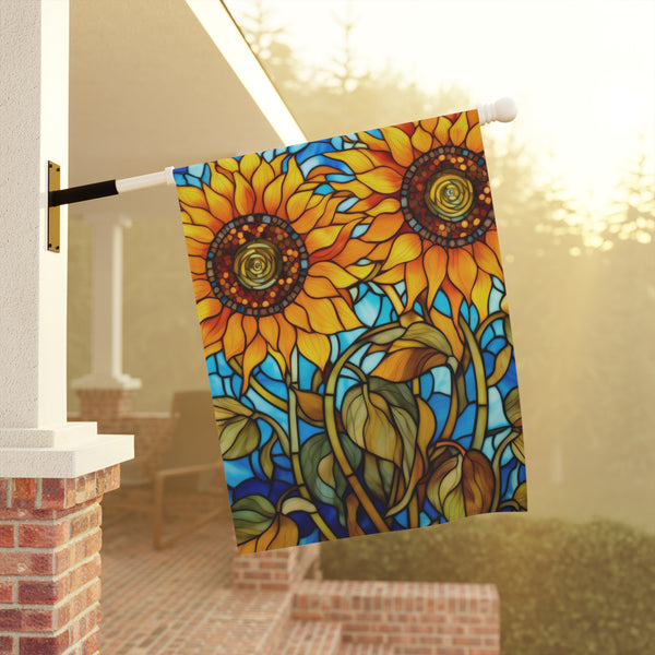 Decorative garden flag with sunflower design hanging on a pole outdoors.