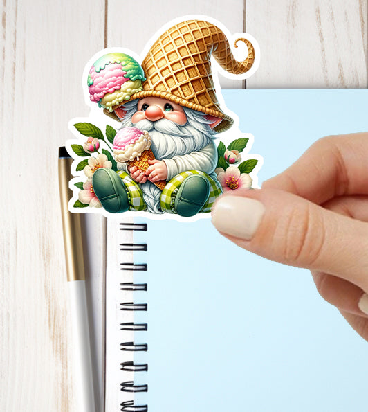 Sticker of a gnome with a waffle hat and ice cream held by a hand, against a light blue background.