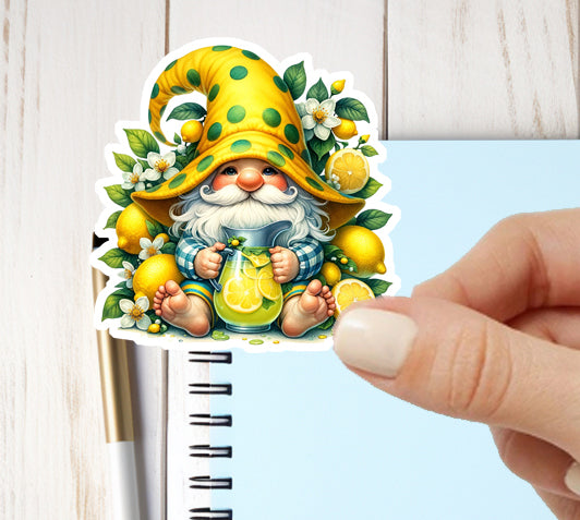 Sticker of a gnome with a yellow hat and lemons held by a hand on a notebook.