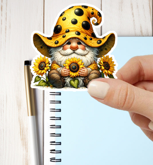 Sticker of a gnome with sunflowers held over a notebook