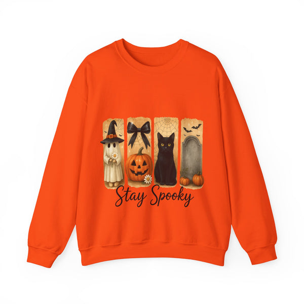 Orange sweatshirt with Halloween-themed design featuring a witch, black cat, pumpkin, and archway on a white background.