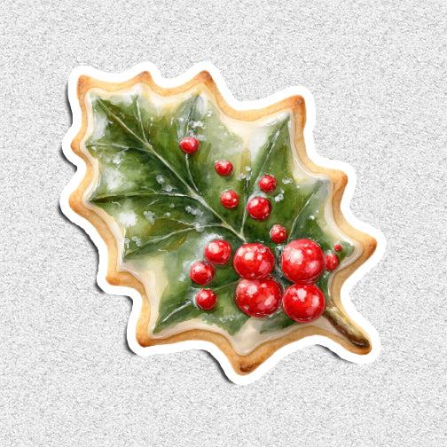 Decorative cookie shaped like a holly leaf with red berries on a textured gray background