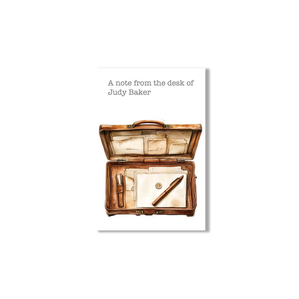 Notebook cover with an open leather-bound notebook containing stationery items on a white background.