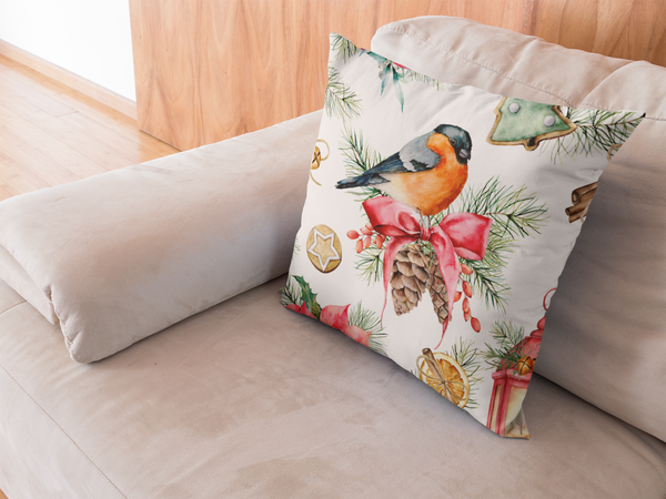 Holiday Christmas throw pillow with birds, pinecones, cookies, and other holiday decor on a tan couch. 