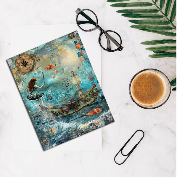 Artistic notebook with mermaid design, glasses, and coffee on a marble surface