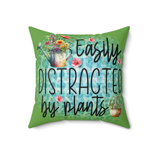 Decorative pillow with 'Easily Distracted by Plants' text and gardening-themed design on a white background