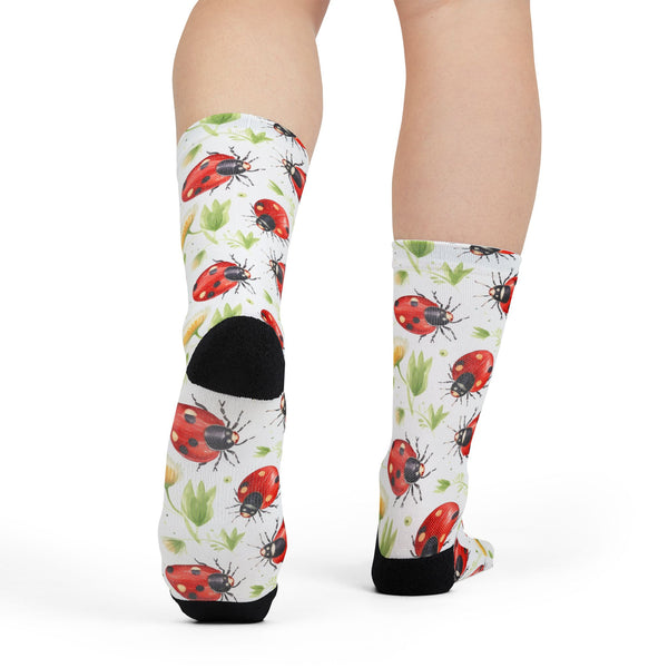 Knee-high socks with ladybug pattern worn by a person on a white background