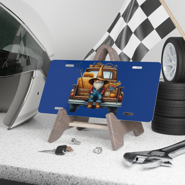 Blue license plate with a gnome and truck design on a stand, surrounded by tools and tires.