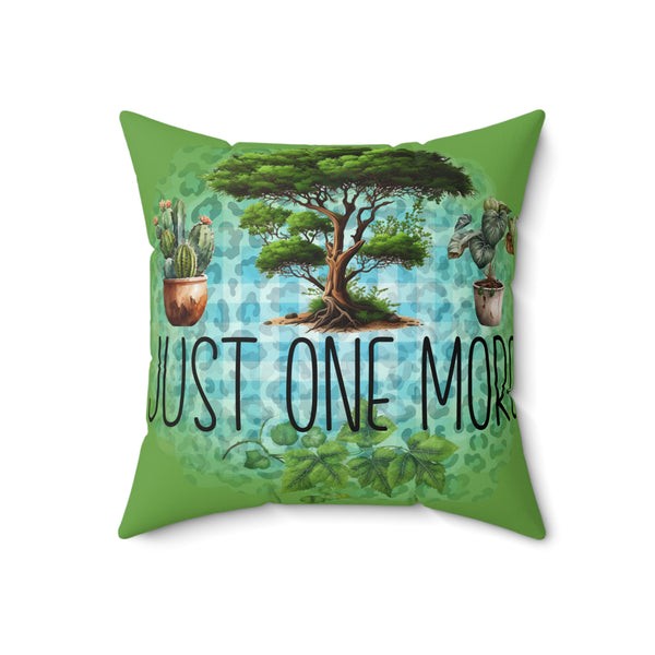 Decorative pillow with a tree and cactus design and 'Just One More' text on a green background.