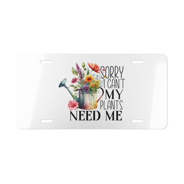 License plate with floral design and text 'Sorry I can't my plants need me' on a white background