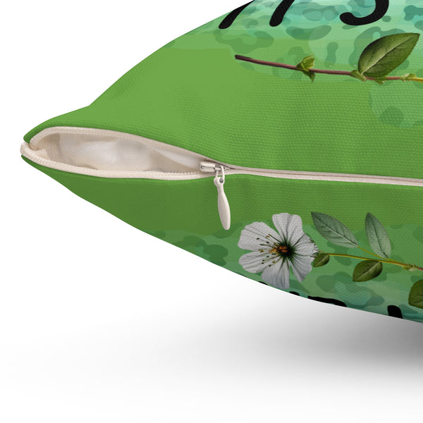 Green pillow with floral design and zipper on a white background