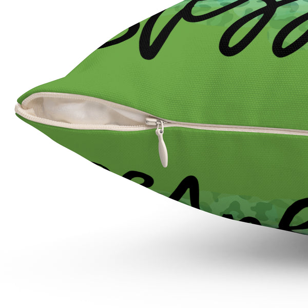 Green pillow with black text and a zipper on a white background