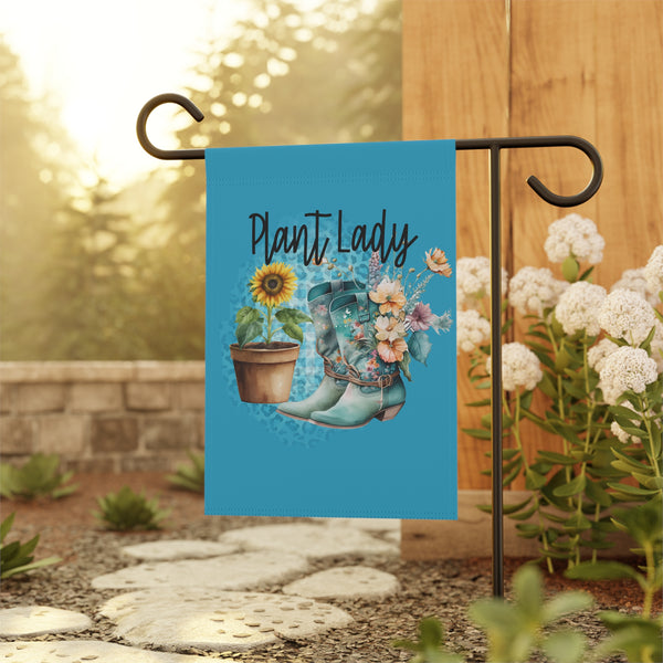 Decorative garden flag with 'Plant Lady' text, boots, and plants on a stand outdoors.