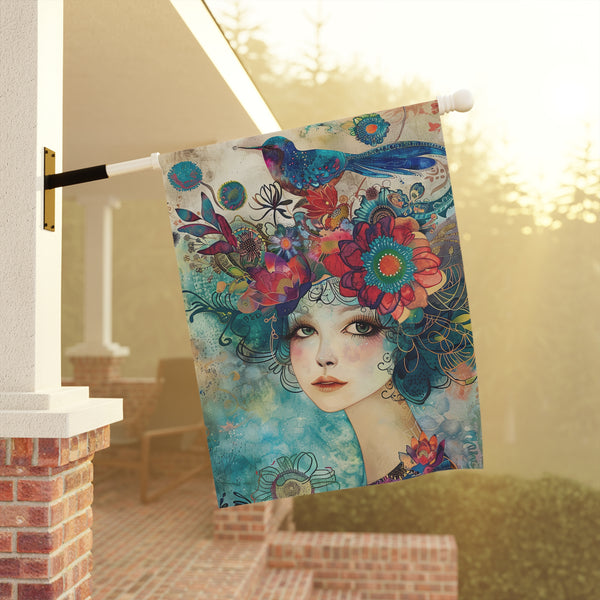 Decorative flag with a colorful design of a woman's face and flowers hanging on a porch.