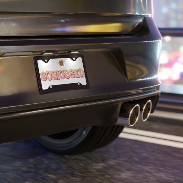 Car rear with 'SUNKISSED' license plate on a blurred background