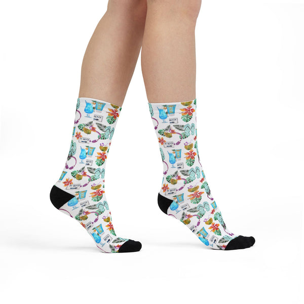 Colorful socks with a pattern of cats and flowers worn by a person on a white background