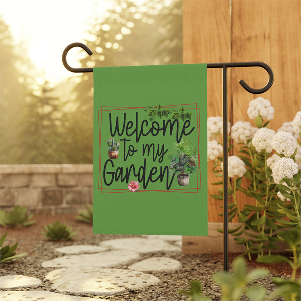 Garden flag with 'Welcome to my Garden' text on a stand with flowers and stones in the background