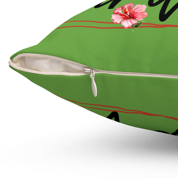 Green pillow with a pink flower and black text on a white background