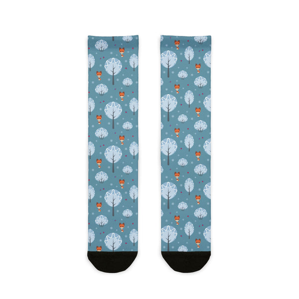 Two socks with a pattern of trees and hot air balloons on a blue background.